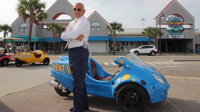 Host Anthony Melchiorri poses in front of a three-wheeled vehicle which he drove to the Lancer Motel. – Bild: 2015,The Travel Channel, L.L.C. All Rights Reserved