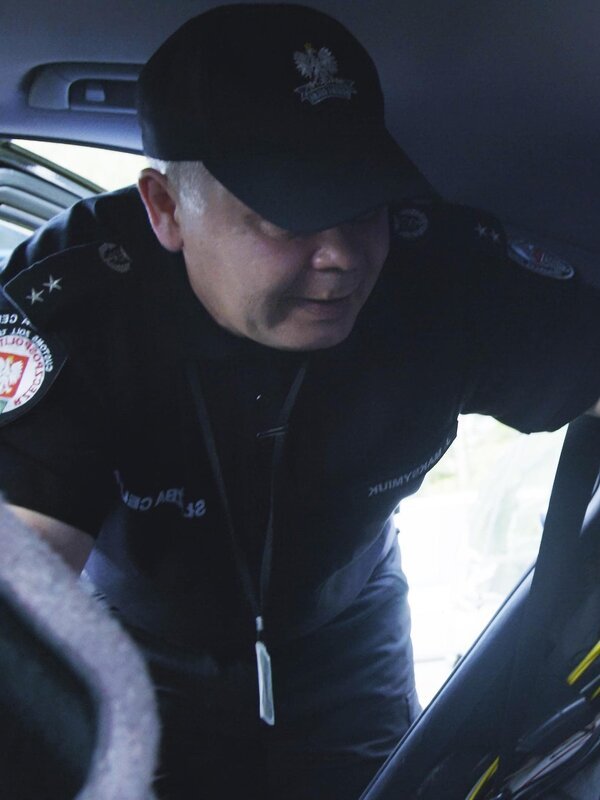 Ein Grenzbeamter kontrolliert einen Kleinbus. – Bild: Discovery Communications, LLC.