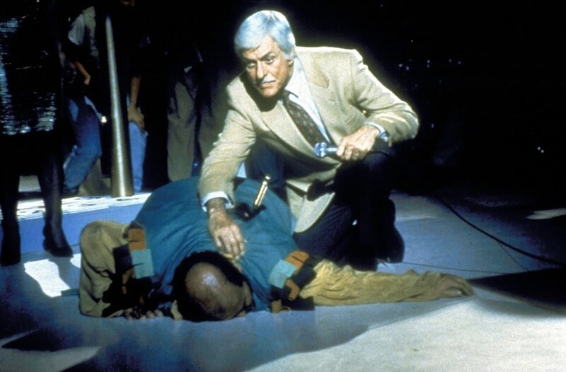 Buddy Blake (Tom DeLuise, l.) stürzt mit einem Messer im Rücken zu Boden. Dr. Sloan (Dick Van Dyke, r.) eilt ihm sofort zu Hilfe. – Bild: Viacom