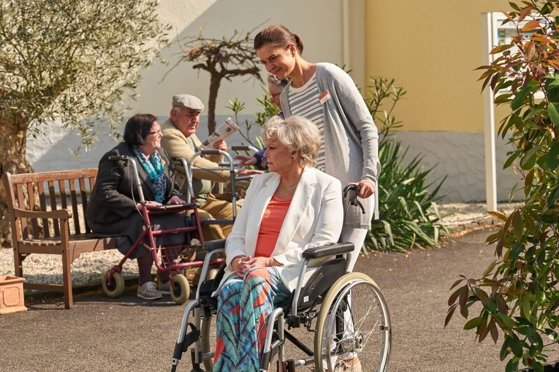 Carolin (Susan Hoecke, r.) ist mit Leib und Seele Altenpflegerin, obwohl ihr Chef alles versucht, ihr den Job madig zu machen. Mit liebevoller Fürsorge und gesundem Menschenverstand gelingt es ihr, auch Elinors (Grit Boettcher, vorne l.) Herz zu erobern … – Bild: SAT.1 / Frank Dicks Carolin (Susan Hoecke, r.) ist mit Leib und Seele Altenpflegerin, obwohl ihr Chef alles versucht, ihr den Job madig zu machen. Mit liebevoller Fürsorge und gesundem Menschenverstand gelingt es ihr, auch Elinors (Grit Boettcher, vorne l.) Herz zu erobern … – Bild: SAT.1 / Frank Dicks