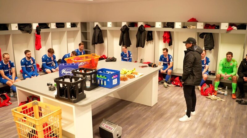 Der FC Energie Cottbus will endlich wieder zurück auf die große Fußballbühne. Doch der Weg dahin ist für das Team um Kult-Trainer „Pele“ Wollitz nach dem vor einem Jahr knapp verpassten Aufstieg schwer und von Rückschlägen in der Saison geprägt. Die rbb Dokumentation begleitet Mannschaft und Trainer ungefiltert aus nächster Nähe beim Kampf um den Aufstieg. Auf dem Platz, in der Kabine und privat. – In der Kabine von Energie Cottbus. – Bild: rbb/​Torsten Michels