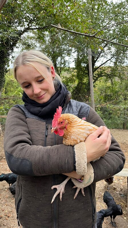 Shanna wird bei der Arbeit im Hühnergehege von kleinen Helfern unterstützt. – Bild: SWR/​Donna Doerbeck