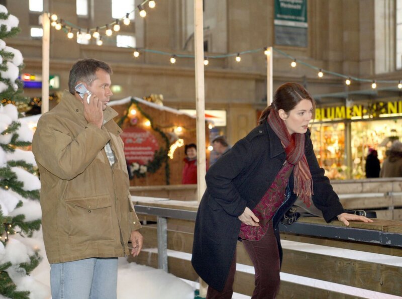 Bei Elena Eichhorn (Cheryl Shepard, rechts), die im weihnachtlich geschmückten Hauptbahnhof den Eisläufern zusieht, setzen plötzlich die Wehen ein. Sie bittet einen Passanten, einen Krankenwagen zu rufen. – Bild: MDR/​Krajewski