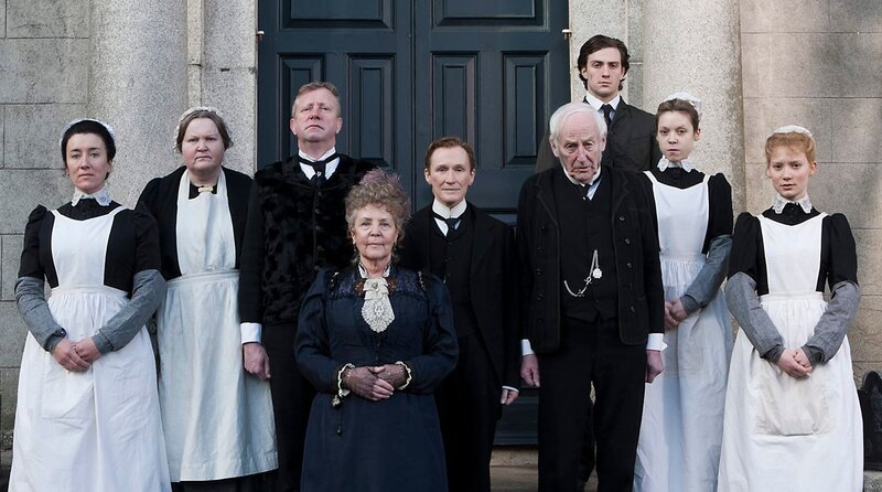 Mary (Maria Doyle Kennedy, l.), Sean Casey (Mark Williams, 3.v.l.), Mrs. Baker (Pauline Collins, 4.v.l.), Albert Nobbs (Glenn Close, m.), Patrick (James Greene, 4.v.r.), Emmy (Antonia Campbell-Hughes), 2.v.r.), Helen (Mia Wasikowska, r.) – Bild: Pandastorm /​ MKNS