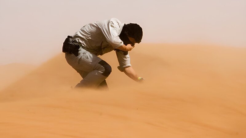 Host Bear Grylls on location in the Sahara desert battling against the wind. – Bild: DCI