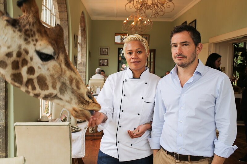 Monica Galetti und Giles Coren füttern eine Giraffe durchs Restaurantfenster – Bild: SRF/​BBC