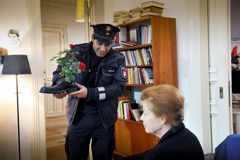 Tarik (Serhat Cokgezen, l.) ist erstaunt: Frau Ohmke (Renate Schroeter, r.) leidet an Demenz und hat Blumen in Schuhe gepflanzt. – Bild: ZDF/​Boris Laewen