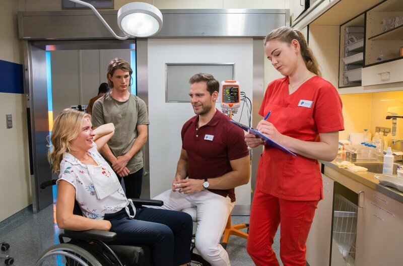 Vanessa Müller (Bea Brocks, l.) wird von ihrem Bruder Fabian (Sven Gielnik, 2.v.l.) mit einem Nasenbeinbruch ins Volkmann-Klinikum gebracht. Vanessa kennt Darius (Moritz Otto, 2.v.r.) noch aus Schulzeiten und scherzt mit ihm, was Louisa (Llewellyn Reichman, r.) eifersüchtig beobachtet. – Bild: ARD/​Andreas Wünschirs