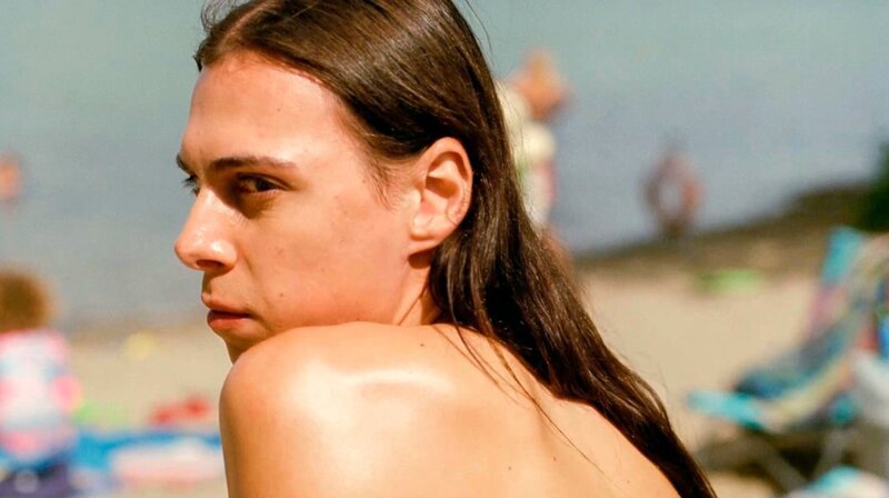 Trans Frau Ren ist Mitte 20, angehende Schriftstellerin und hat gerade ihren Job verloren. Ausgerechnet jetzt steht der Strandurlaub mit ihren liebevollen, aber ziemlich temperamentvollen italo-kanadischen Eltern und ihrer rebellischen kleinen Schwester Siena an. – Ren (Carmen Madonia) wartet auf den richtigen Moment, um von der Entlassung zu erzählen. – Bild: rbb/Salzgeber Trans Frau Ren ist Mitte 20, angehende Schriftstellerin und hat gerade ihren Job verloren. Ausgerechnet jetzt steht der Strandurlaub mit ihren liebevollen, aber ziemlich temperamentvollen italo-kanadischen Eltern und ihrer rebellischen kleinen Schwester Siena an. – Ren (Carmen Madonia) wartet auf den richtigen Moment, um von der Entlassung zu erzählen. – Bild: rbb/Salzgeber