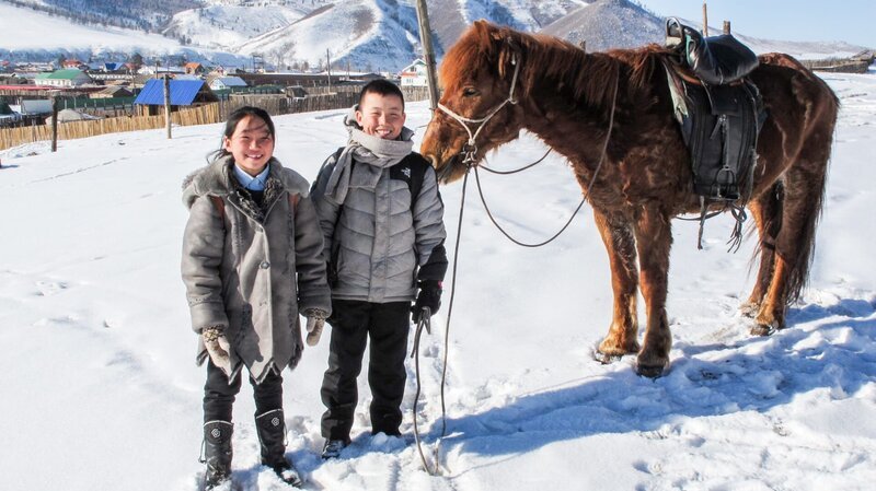 Delgertsetseg (li.), Tuguldur (Mi.) und der ‚Braune‘. Die beiden mongolischen Nomadenkinder haben einen ganz besonderen Schulweg. – Bild: 3sat