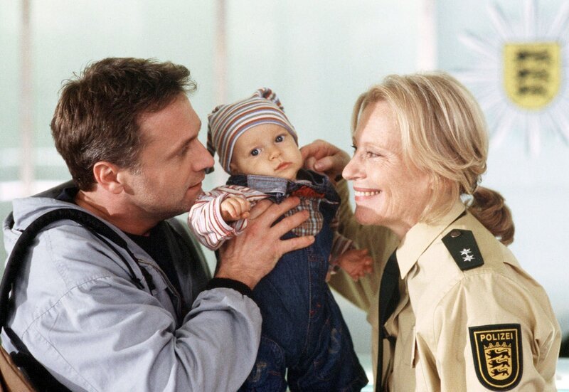 Leo (Bernhard Schir) bittet seine Kollegin Hilda (Maren Kroymann), auf den kleinen Felix (Maximilian und Matthias Bäumler) aufzupassen. – Bild: HR/​Degeto/​Joachim Bischoff