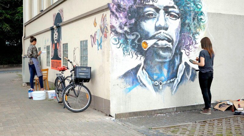 Angela Davis und Jimi Hendrix werden auf die Außenwände der Rockakademie Herford gemalt. – Bild: WDR/​RB Filmwerk