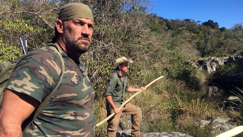 L-R: EJ Snyder und Jeff Zausch halten Speere am Fluss. – Bild: Discovery Channel /​ Discovery Communications