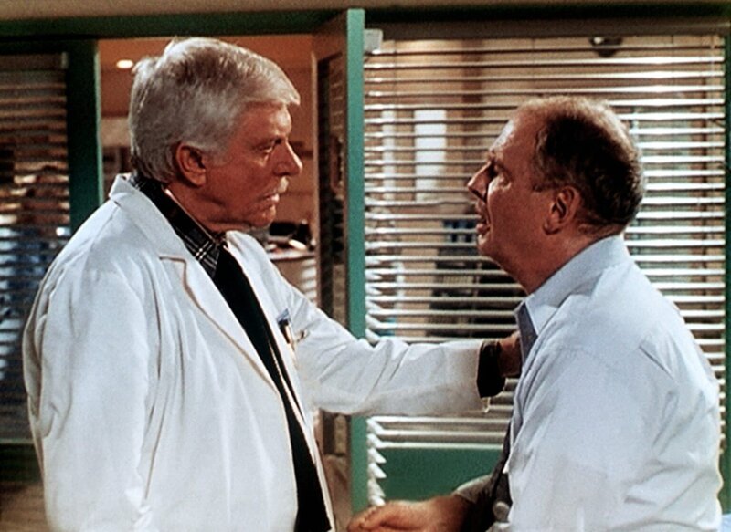 Dr. Mark Sloan (Dick Van Dyke, l.) leistet dem Chirurgen Ray Huxley (Nicholas Pryor, r.), einem alten Freund, der einen Herzinfarkt erlitten hat, erste Hilfe. – Bild: Viacom Lizenzbild frei