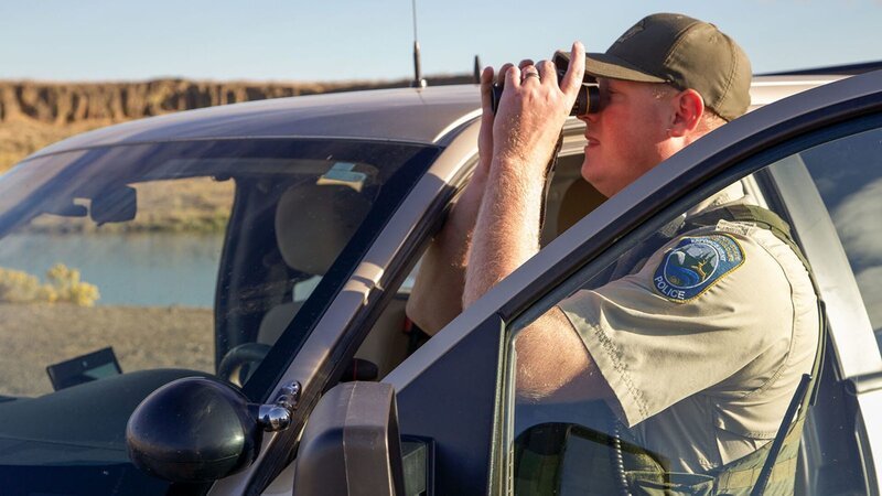 Officer Bushing checking out the surroundings with binoculars. – Bild: Animal Planet /​ Discovery Communications