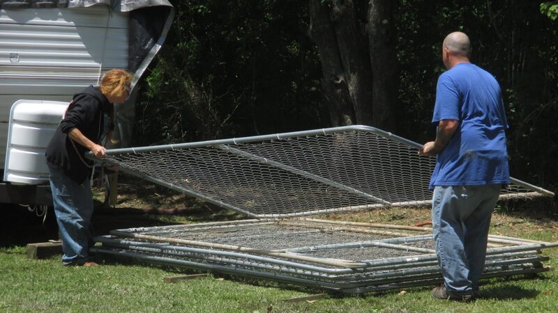 Tia & Troy being filmed lifting a kennel fence. – Bild: Discovery Communications