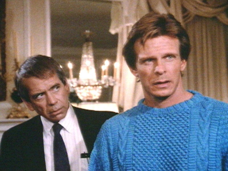 Kommissar Underwood (Lane Smith, li.) kann nicht glauben, dass Rick Banner (Marc Singer) der verschollene Universalerbe sein soll. – Bild: Warner TV Serie