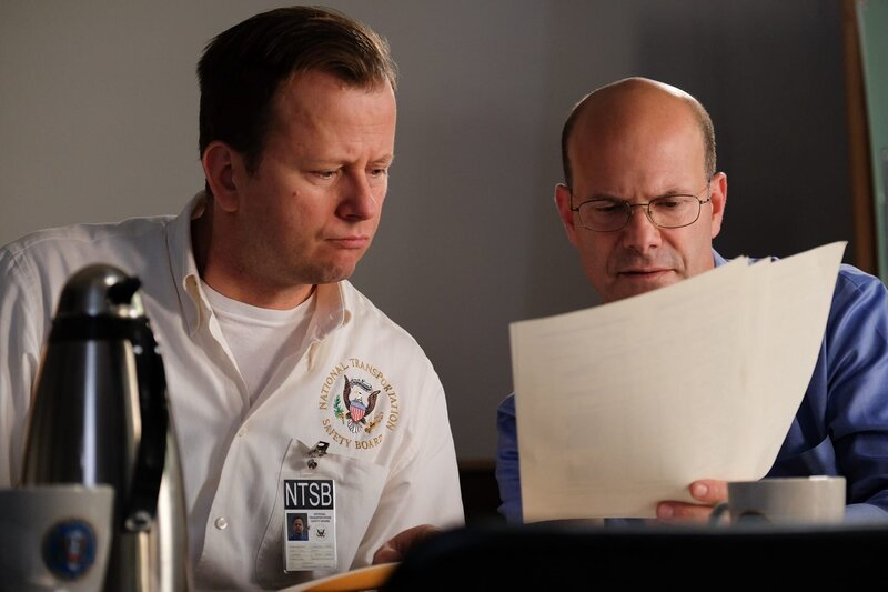 Flugunfallermittler John Delisi (gespielt von Darrin Baker) berät sich mit einem anderen Ermittler (gespielt von einem Hintergrunddarsteller). (Bildnachweis: Cineflix/​Darren Goldstein) – Bild: Copyright © The National Geographic Channel.