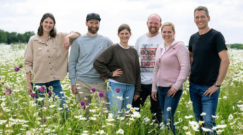 Seit 15 Jahren erzählt „Land & lecker“ spannende Geschichten von und mit Menschen vom Land, von deren Erzeugnissen und wie diese in der modernen Küche kreativ zubereitet werden können. „Land & lecker“ reist dafür kreuz und quer durch Nordrhein-Westfalen und präsentiert Lebensmittel, die mit viel Leidenschaft hergestellt werden. Auf dieser Reise besuchen sich die sechs Teilnehmer:innen gegenseitig auf ihren Höfen und schenken ihren Gästen eine unvergessliche Zeit. Am Ende vergeben die Gäste Punkte für das Genussprogramm und den Besuch auf dem Hof. Wer hat den schönsten „Land & lecker“-Tag veranstaltet? – Mitwirkende, v.l. Inga Flachmeier, Melvin Berger, Lisa Schäfer, Rainer Overkämping, Katharina Marseille und Jochen Kanders, Gastgeber der heutigen ersten Folge. – Bild: WDR/​Melanie Grande