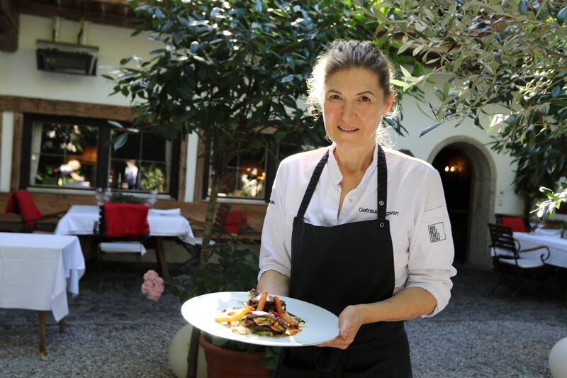 Portrait halbnah von Haubenkoechin Traudi Sigwart mit Wildgerichtwährend ServusTVs „Höchster Genuss im Alpbachtal“ im Haubenrestaurant „Sigwarts Tiroler Weinstuben „in Brixlegg, Tirol, Österreich am 28.09.2023 – Bild: ServusTV /​ Terra Mater