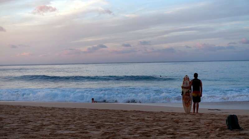 Ein Surfer schaut sich die Wellen an bevor es ins warme Wasser geht. Am Sunset Beach an der North Shore. – Bild: ZDF und NDR/LOUPEFILM. Ein Surfer schaut sich die Wellen an bevor es ins warme Wasser geht. Am Sunset Beach an der North Shore. – Bild: ZDF und NDR/LOUPEFILM.