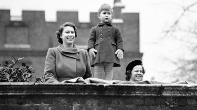 Prinzessin Elizabeth mit ihrem zweijährigen Sohn Prinz Charles, Sie beobachten die Prozession von der Mauer des Clarence House, während Königin Juliana und Prinz Bernhard der Niederlande zur Guildhall fahren. – Bild: SWR/​1950 PA Images/​Alamy Stock Photo