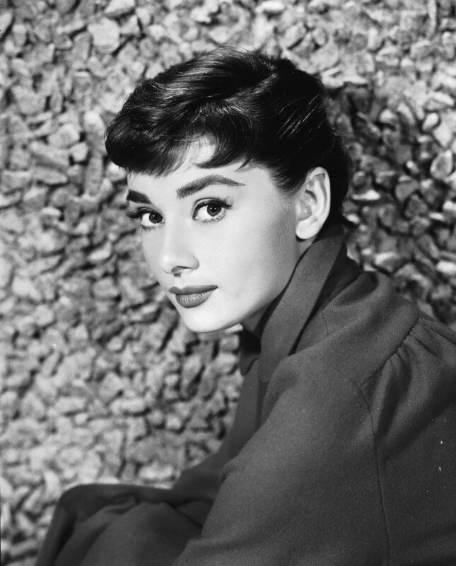 Portrait of Belgian-born American actress Audrey Hepburn (1929 – 1993) as she sits by a stone wall, early 1950s. – Bild: Hulton Archive/​Getty Images