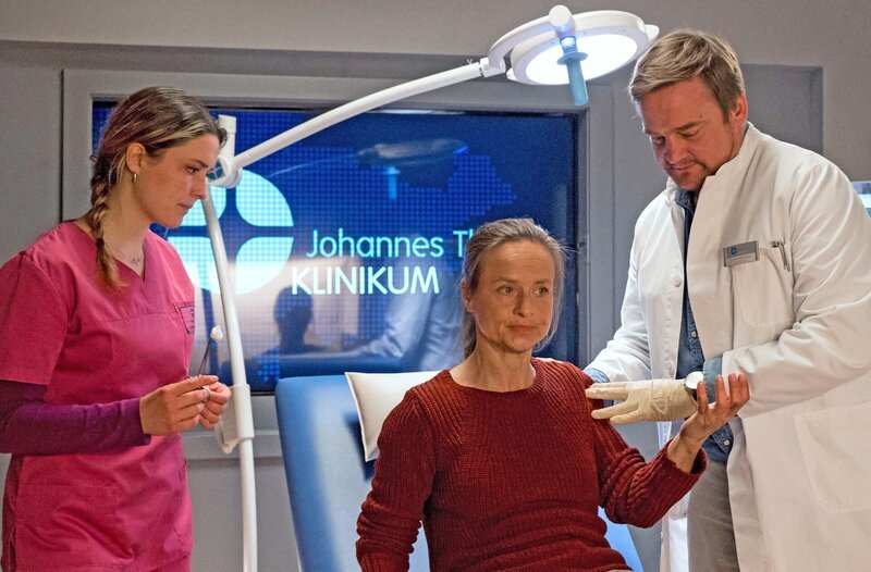 Marie Obischu (Christine Kutschera, M.) hat eine ernstzunehmende Wunde an der Hand. Marc Lindner (Christian Beermann, r.) fällt sofort ein bedeutendes Detail auf (mit Isabella Krieger, l.). – Bild: ARD/​Jens-Ulrich Koch