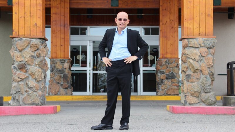 Host Anthony Melchiorri poses in front of the Anchorage Lofts Hotel in Anchorage, Alaska. – Bild: The Travel Channel, L.L.C.