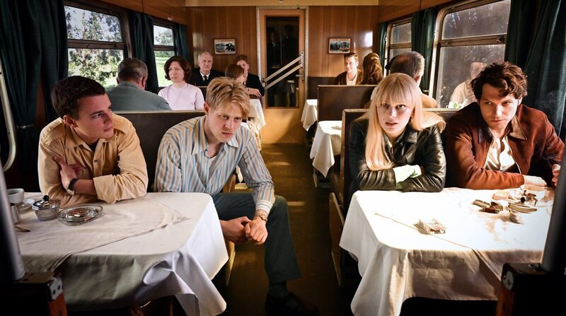 Karriere im Osten oder Unsicherheit im Westen (v. li. n. re.:) Peter (Johannes Meister), Siggi (Karl Schaper), Carla (Alli Neumann) und Sasha Goldberg (Jeff Wilbusch) disktutieren. – Bild: ZDF und ARD Degeto/REAL FILM/AMALIA Film/Bernd Schuller. Karriere im Osten oder Unsicherheit im Westen (v. li. n. re.:) Peter (Johannes Meister), Siggi (Karl Schaper), Carla (Alli Neumann) und Sasha Goldberg (Jeff Wilbusch) disktutieren. – Bild: ZDF und ARD Degeto/REAL FILM/AMALIA Film/Bernd Schuller.
