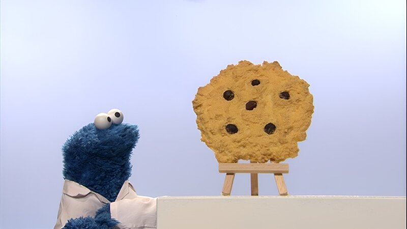 Krümel entdeckt, dass ein kleiner Keks ganz groß erscheinen kann. Lecker! – Bild: NDR/​Studio Hamburg Produktion/​Sesame workshop