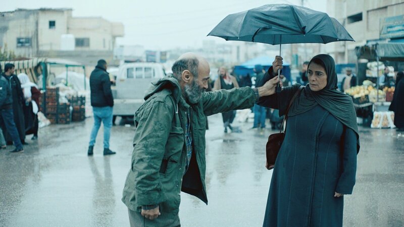 Der Regen gibt Issa (Salim Daw, l.) Gelegenheit, seinem heimlichen Schwarm Siham (Hiam Abbass, r.) endlich näher zu kommen. – Bild: ZDF und Christophe Graillot./Christophe Graillot Der Regen gibt Issa (Salim Daw, l.) Gelegenheit, seinem heimlichen Schwarm Siham (Hiam Abbass, r.) endlich näher zu kommen. – Bild: ZDF und Christophe Graillot./Christophe Graillot