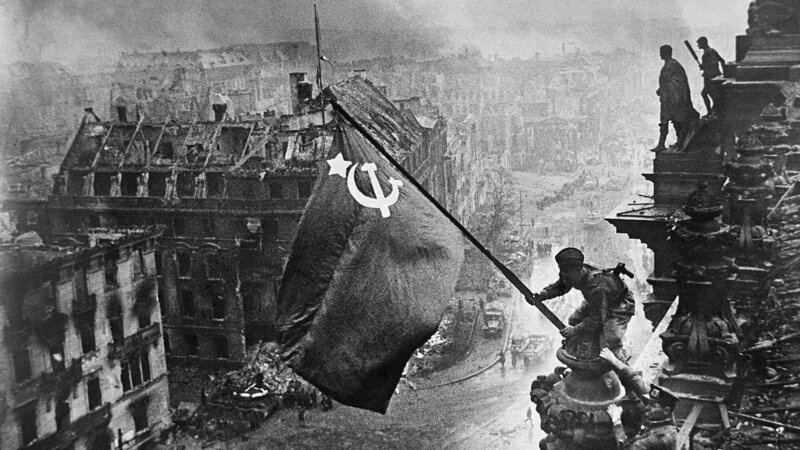 Soldaten hissen die sowjetische Flagge auf dem Reichstag über dem zerbombten Berlin. Ein ikonisches Bild vom Ende des Zweiten Weltkriegs. – Bild: WAG TV Limited/​ ITAR-TASS News Agency/​ Alamy Stock Photo/​ WeltN24 GmbH