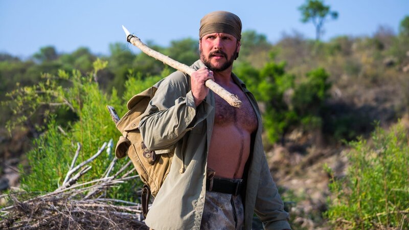 Joe Teti walking along bushes with his backpack and spear. – Bild: Discovery Communications