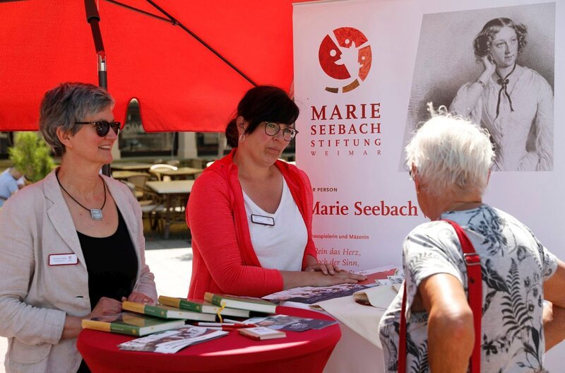 Pflegedienstleisterin Antje Martini (m.) am Infostand der Marie-Seebach-Stiftung. – Bild: MDR/​Bernd Lindig