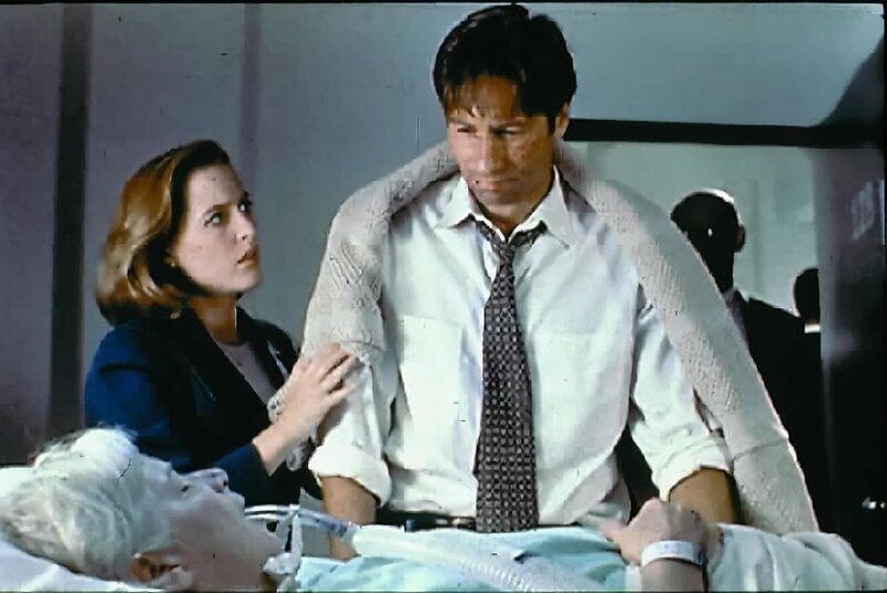 Mrs. Mulder (Rebecca Toolan, vorne) wurde mit einem Schlaganfall in ein Krankenhaus eingeliefert. Scully (Gillian Anderson, l.) steht Mulder (David Duchovny, r.) bei, der das Leben seiner Mutter mit den Kräften eines Außerirdischen retten möchte. – Bild: ProSieben MAXX