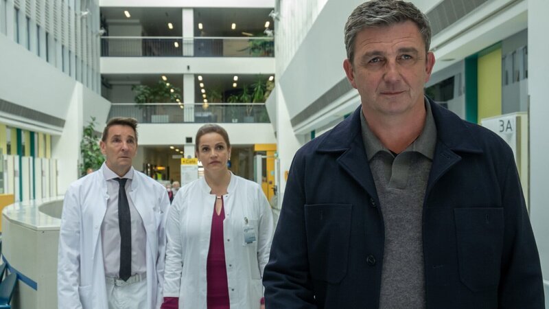 Dr. Martin Gruber (Hans Sigl, r.) macht Ernst: Er verabschiedet sich, um Ellmau zu verlassen. Dr. Alexander Kahnweiler (Mark Keller, l.) und Dr. Vera Fendrich (Rebecca Immanuel, M.) können es nicht glauben. – Bild: ZDF und Erika Hauri./​Erika Hauri