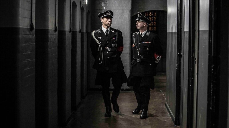 L-R: Reinhard Heydrich (Daniel Chapple) und Heinrich Himmler (Darsteller unbekannt). – Bild: Andrew Hayes-Watkins