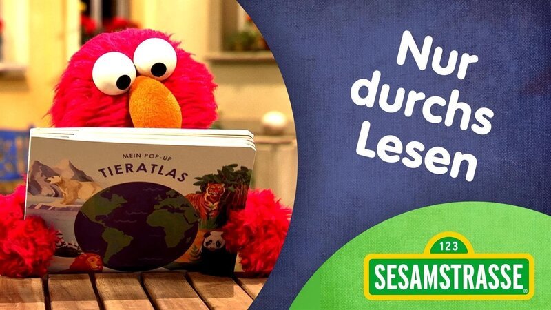 Elmo überzeugt Wolf, den Lesemuffel, mit einem Song, das Lesen toll ist. – Bild: NDR/​Studio Hamburg Produktion/​Sesame workshop