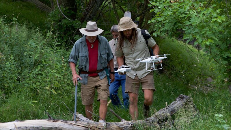L-R: Eric Drummond, Chad Ollinger, Charlie Snider carry a drone through the trees. – Bild: Discovery Communications, LLC