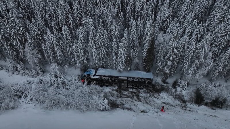 Ein Lastwagen, der eine Ladung Müll transportiert, liegt auf der Seite, weit weg von der Straße. – Bild: National Geographic