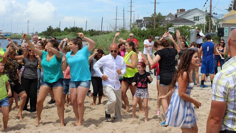 Anthony dances with a flash mob of dancers at Baby Beach, as seen on Travel Channel’s Hotel Impossible. – Bild: The Travel Channel, L.L.C.