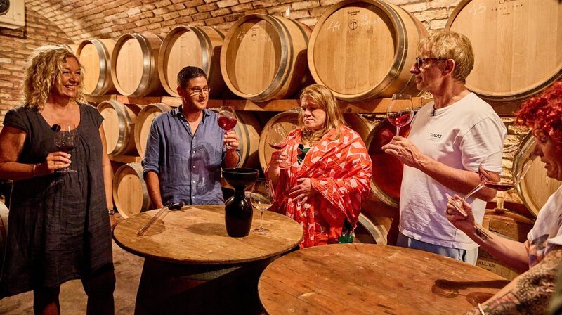 Am Abend sind die Camper bei Winzer Ivan (2.n.li.) zu Besuch. Während Oliver und Cossu den Tisch für einen schönen Abend auf dem Weingut vorbereiten, zeigt Ivan, Bettina, Gisa, Ingolf und Lucy seinen Weinkeller – natürlich inklusive Geschmacksproben. – Bild: NDR/​Daniel Wolcke/​beckground tv