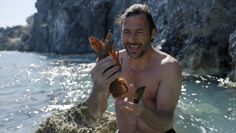 Hazen Audel findet auf der Suche nach Nahrung unter Wasser einen Hummer. – Bild: Alex Holden /​ National Geographic/​Icon Films