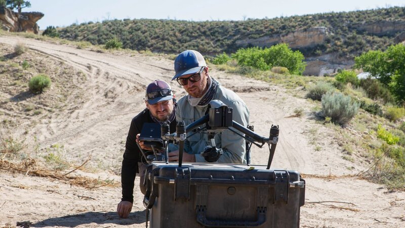 Ryan (drone operator) and crew look at the drone resting on top of a pelican case. – Bild: Craig Carpenter /​ Discovery Channel