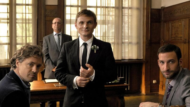 ARD Degeto WIR TUN ES FÜR GELD, am Sonntag (05.08.18) um 13:30 Uhr im ERSTEN. Der Bräutigam Moritz (Florian Lukas, 2. v. re.) wartet gemeinsam mit dem Standesbeamten, Bernd (Matthias Weidenhöfer, re) und Wolfi (Daniel Aichinger, li.) auf die Braut. | ©ARD Degeto/​Hans-Joachim Pfeiffer – Bild: ARD Degeto/​Hans-Joachim Pfeiffer