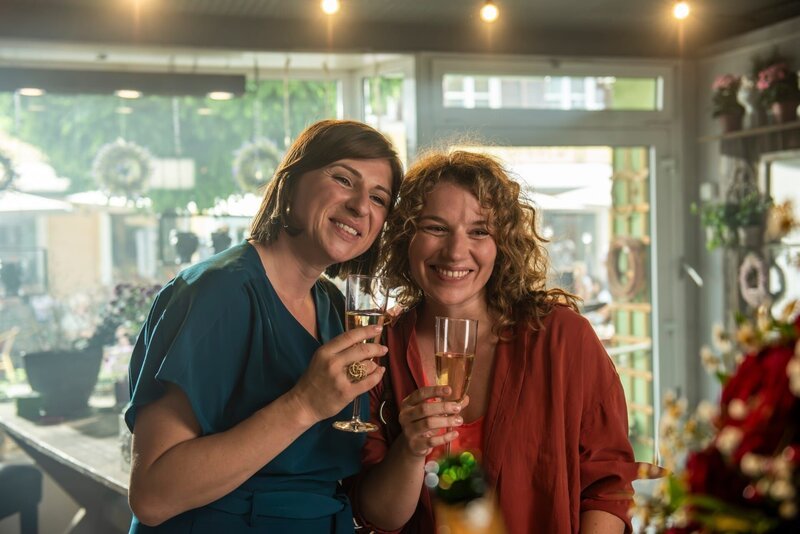 Der Tag beginnt gut. Im Blumenladen gibt es Grund zu feiern für Toni (Lisa Jopt, l.) und Elena (Antonia Bill, r.). – Bild: Susanne Bernhard /​ ZDF