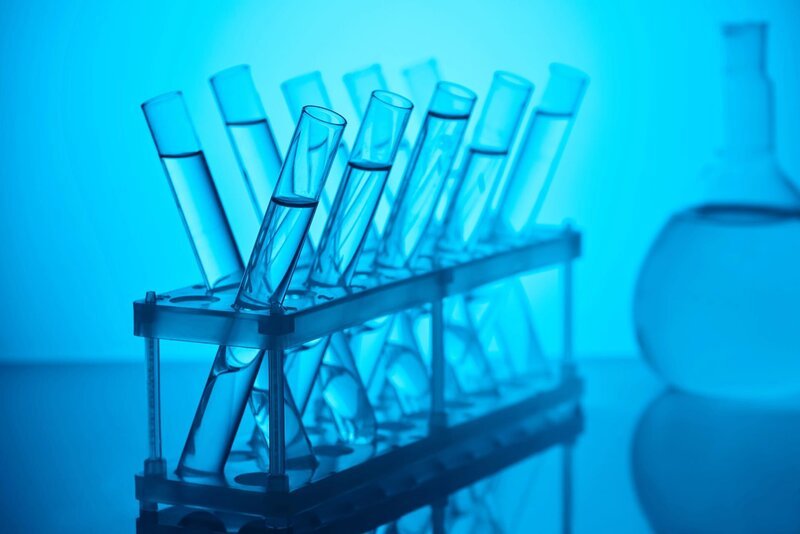 Glass tubes with liquid on stand for chemical analysis in laboratory on blue. – Bild: Depositphotos