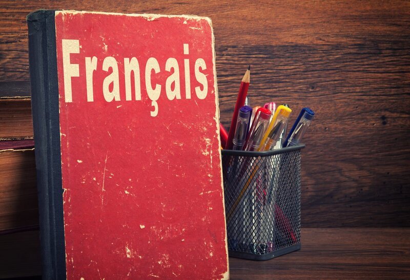 learning French concept. book on a wooden background. – Bild: Depositphotos / spaxiax learning French concept. book on a wooden background. – Bild: Depositphotos / spaxiax
