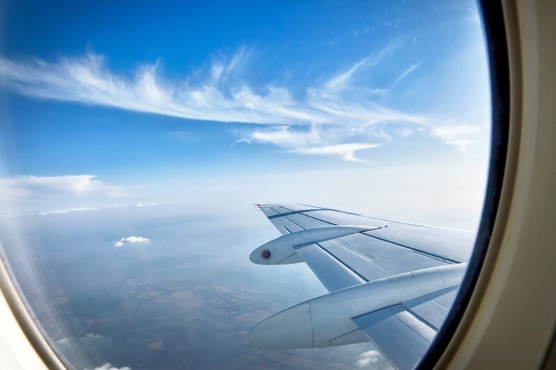 Blick über einen Flugzeugflügel im Flug – Bild: Depositphotos /​ Mojzes Igor /​ LuckyBusiness Photo Studio by Igor Mojzes and Agota Janosi